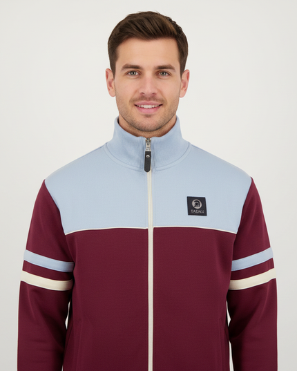 Man wearing burgundy and light blue track top, upper body