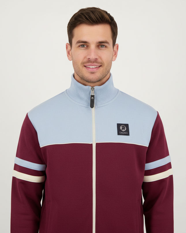 Man wearing burgundy and light blue track top, upper body