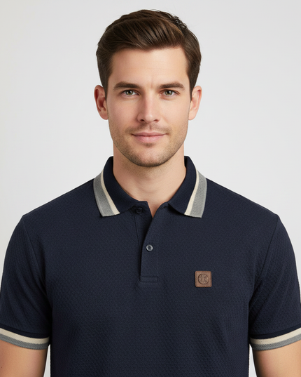 Man wearing navy polo shirt with grey tipped collar, upper body
