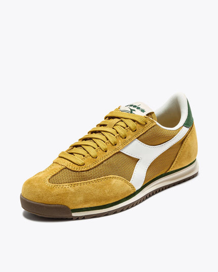 Yellow sneaker with white accents on a light beige background