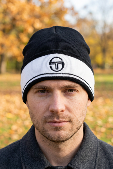 White male model wearing the black beanie in a park on a bright autumn day