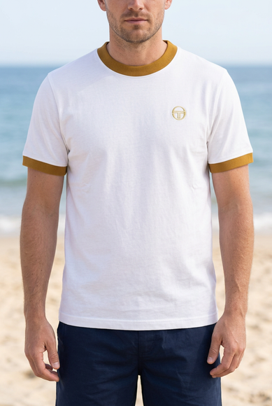 White male model wearing the white T-shirt with mustard trims on a summer beach
